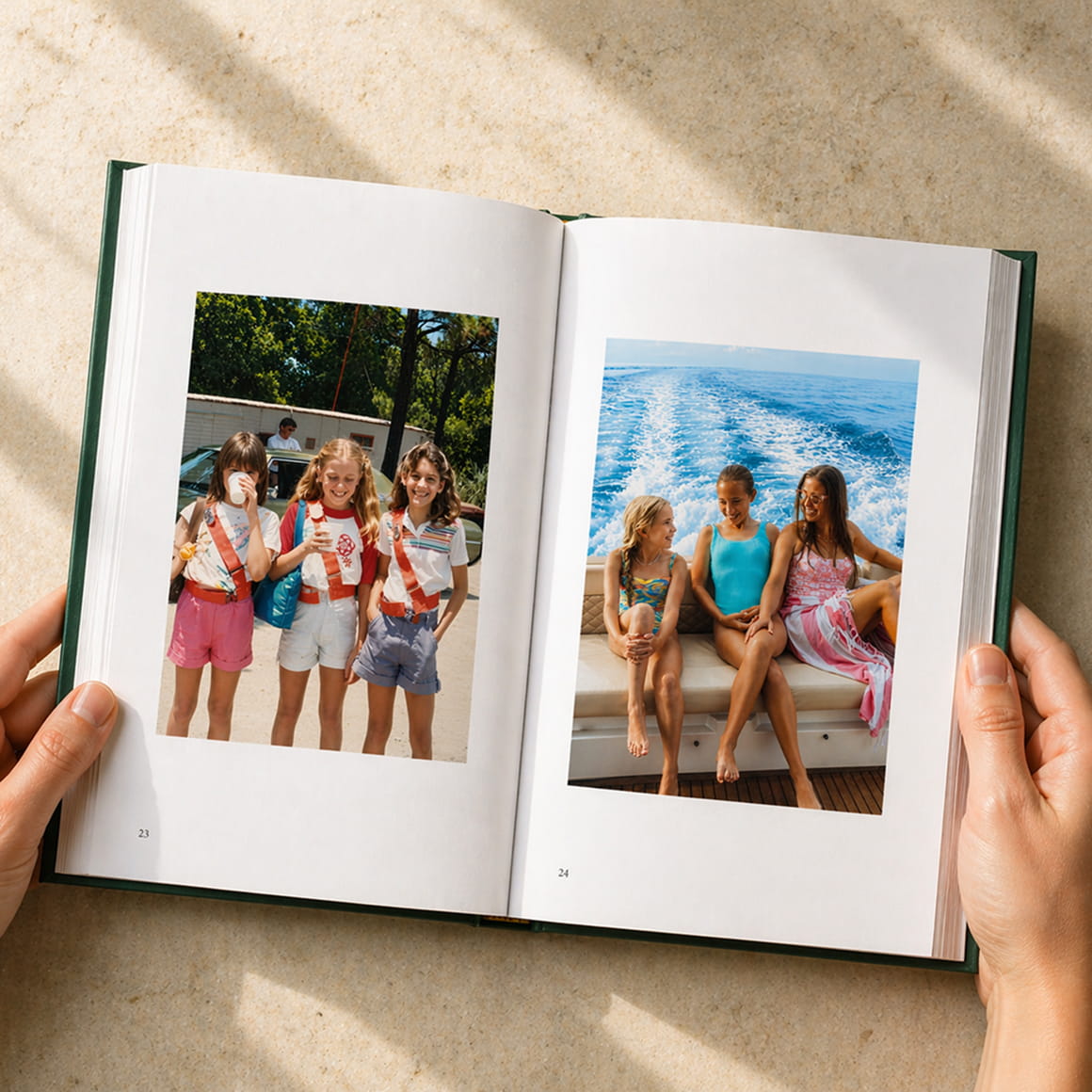 Hands holding an open memoir showing a two-page photo spread