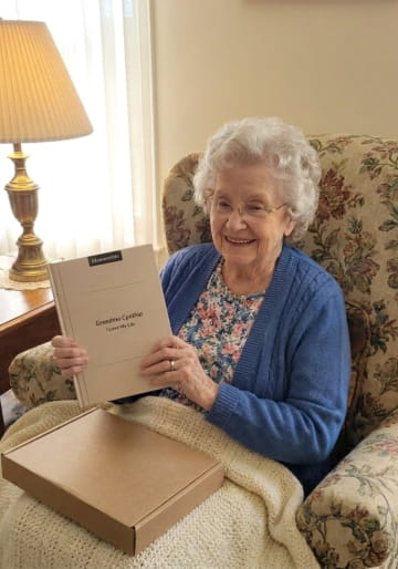 Grandmother unboxing her Memowrite life story book in her armchair