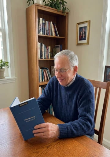 Man reading his navy Memowrite life story at the dining table